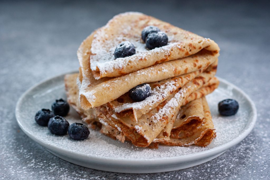 Homemade crepes served with blueberries and powdered sugar, France - Leisure Travel Enterprises 