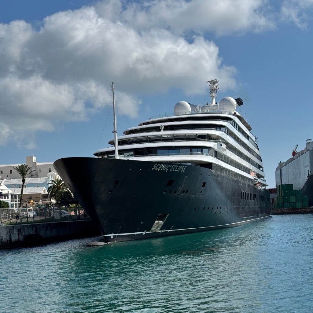 Scenic Cruise ship docked in Bermuda harbour with town in the background - Leisure Travel Enterprises