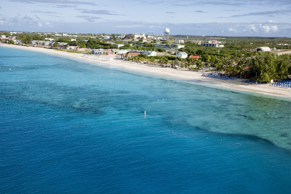 Beautiful blue water and lounge chairs on Caribbean beach - Leisure Travel Enterprises