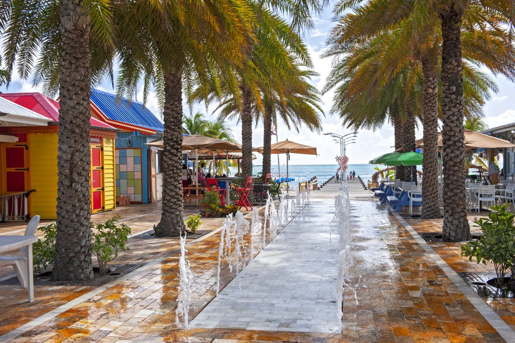 water feature in the middle of walkway with bars and restaurants overlooking the ocean, Philipburg, St. Martin - Leisure Travel Enterprises