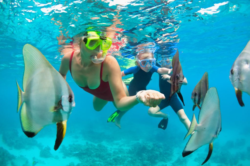 Mother, kid in snorkeling mask dive underwater with tropical fishes - Leisure Travel Enterprises 