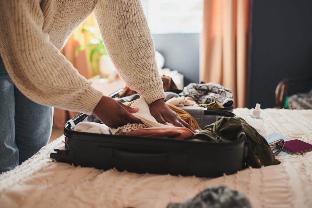 Woman packing her things into a suitcase - Leisure Travel Enterprises