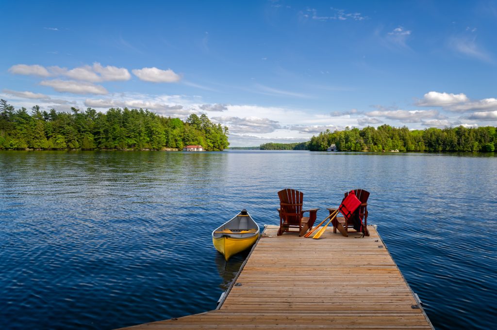 Adirondack chairs and canoe on a cottage dock - LTE